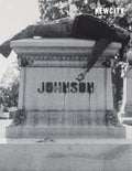A person with long hair lies on their back on top of a stone tombstone marked JOHNSON, with one arm dangling over the edge in a style reminiscent of the November 2026 Issue: Film 50 (Print Edition).