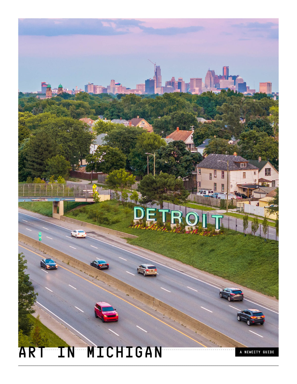 Against the vibrant backdrop of a highway lined with cars passing a large DETROIT sign amid lush greenery—framed by houses and the Detroit city skyline at sunset—the energy of Detroit artists and the spirit of Michigan’s art scene come alive, as showcased in *Art in Michigan: A Guide for Collectors, Curators and the Curious (Digital Edition)*.