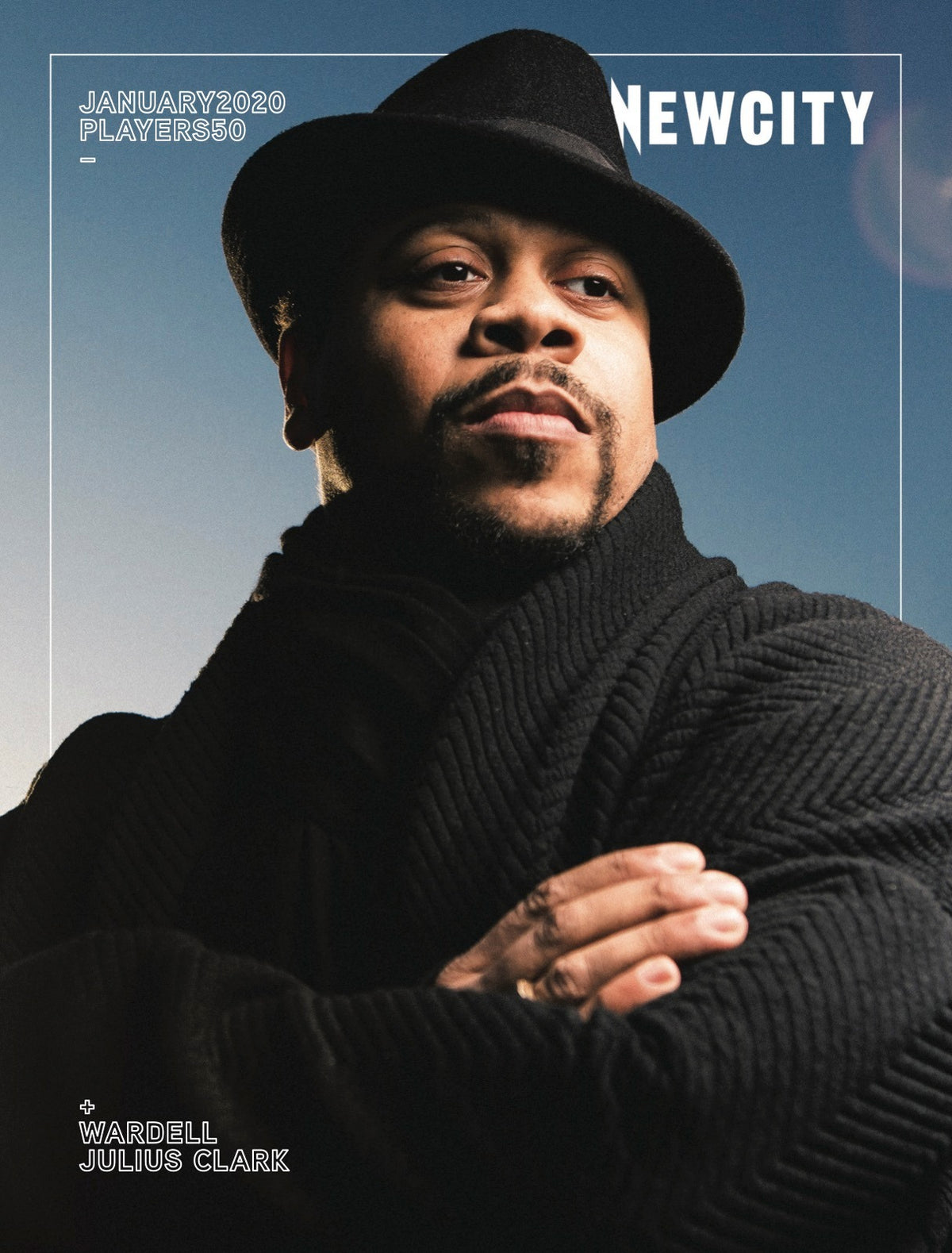 A man in a black hat and coat crosses his arms and looks confidently upward on the cover of Newcity's January 2020 Issue: Players 50, featuring Wardell Julius Clark—a celebrated figure known for his dynamic presence in theater.