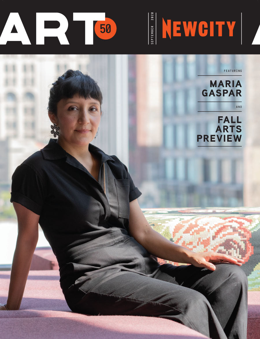 A woman with short dark hair in a black jumpsuit sits on a pink bench by a window. The NEWCITY ART cover highlights Maria Gaspar and Fall Arts Preview—explore more with a Newcity Monthly Subscription.