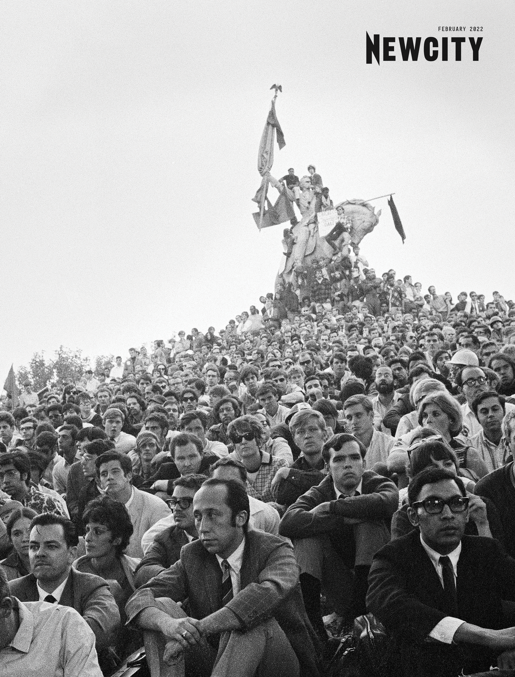 A large crowd of people, primarily young adults, gather on and around a statue, some waving flags. The atmosphere is historic and intense, reflecting themes of equity and identity. "NEWCITY" appears in the top right corner of the cover for the February 2022 Issue: Newcity at 36 (Digital Download).