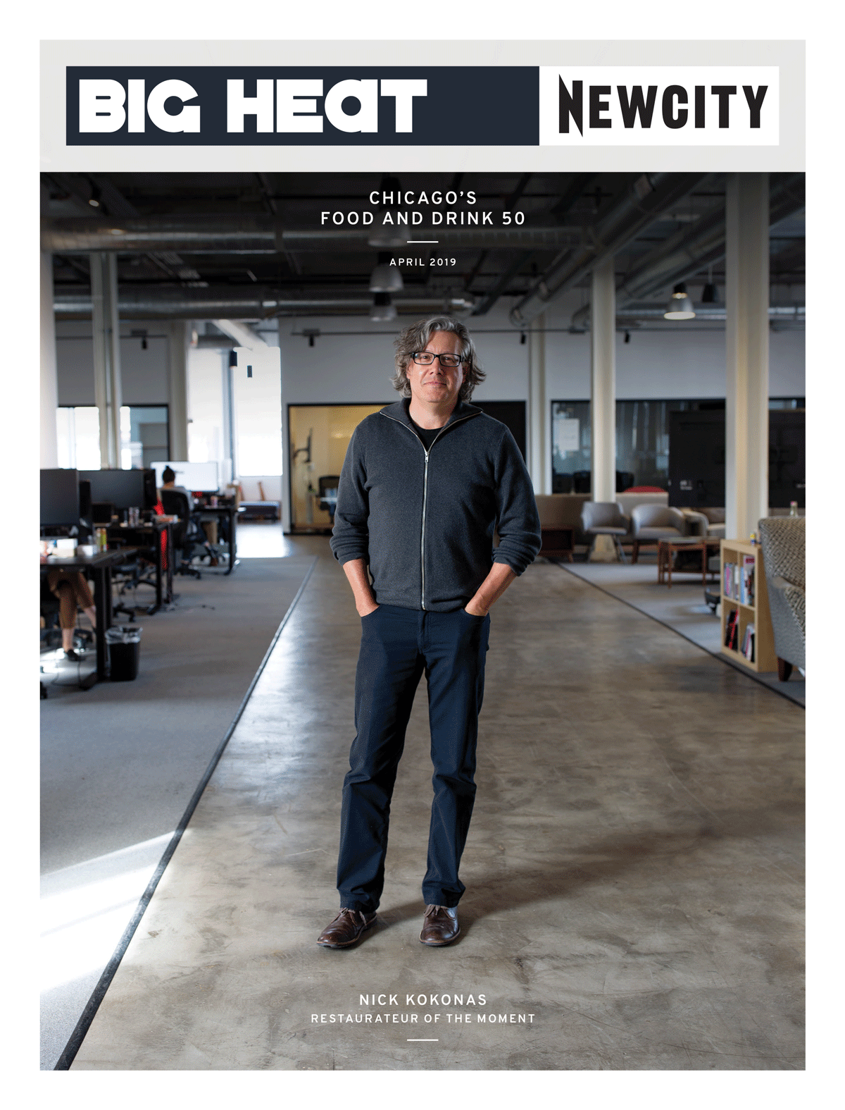 A man with glasses and gray hair stands in a modern open office space. The cover of the April 2019 Issue: Big Heat Food & Drink 50 features headlines such as BIG HEAT, NEWCITY, and Nick Kokonas: Restaurateur of the Moment, celebrating his leadership among the behind-the-kitchen players shaping Chicago’s dining scene.