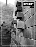 Black and white photo of a brick wall with rectangular blocks jutting out at angles. "July 2021: Sheboygan" appears in the corner, resembling a magazine cover. The composition evokes the innovative spirit of contemporary art, reminiscent of installations at the John Michael Kohler Arts Center’s Art Preserve.